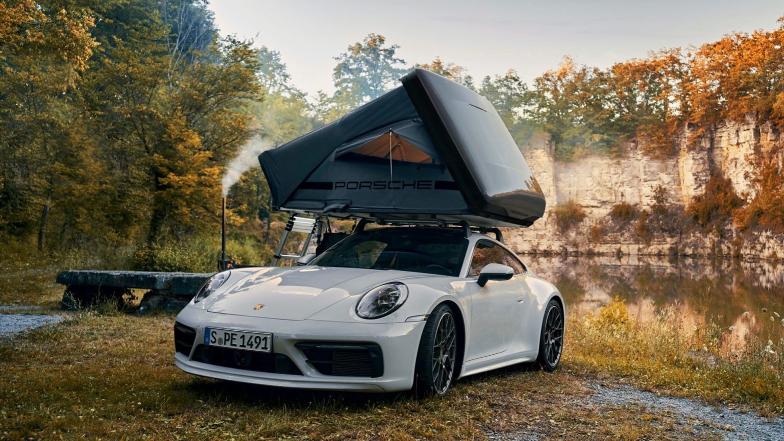 Auf einem Porsche 911 ist ein Zelt aufgebaut.