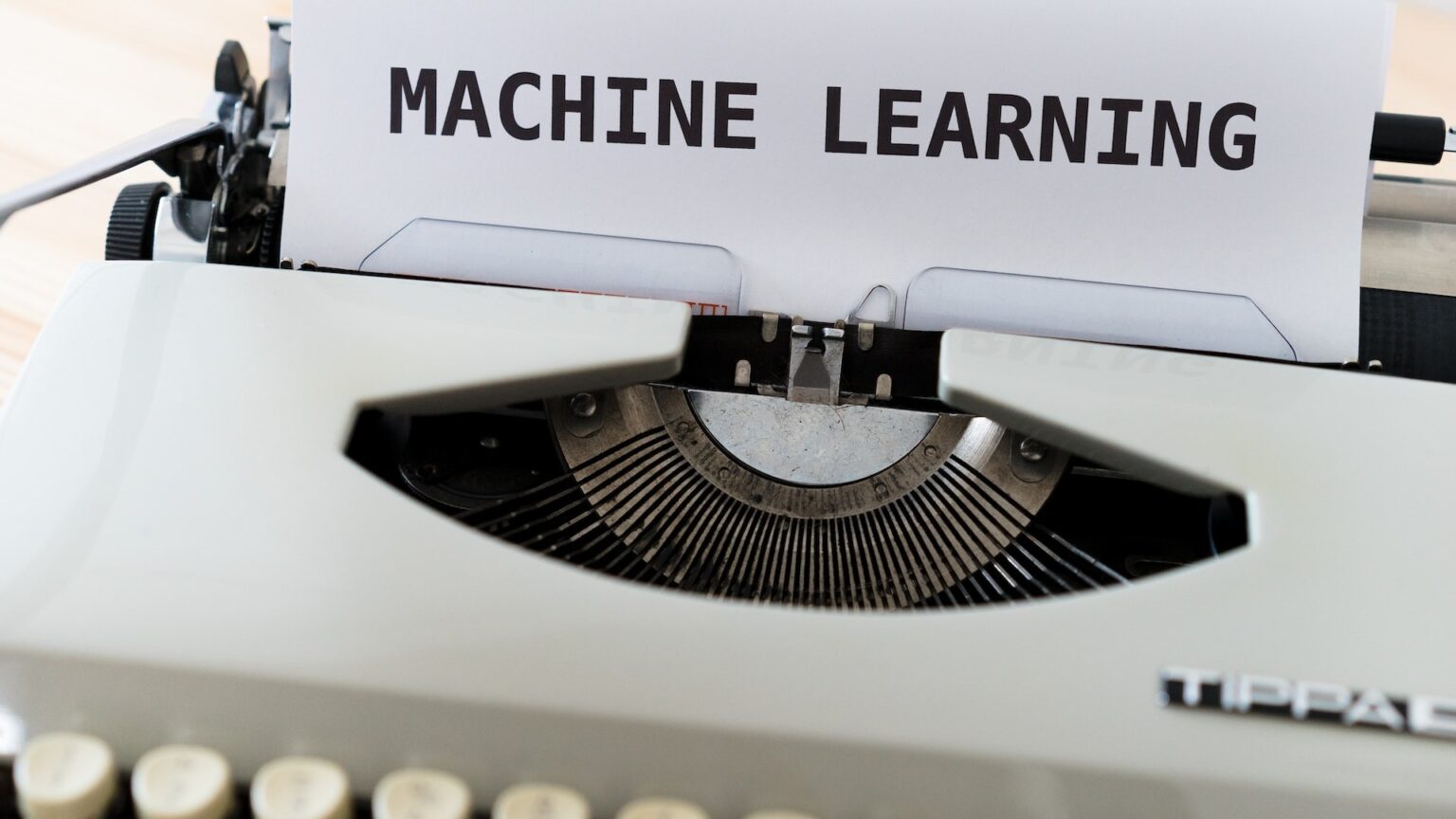 Eine Schreibmaschine tippt das Wort "Machine Learning", eine Form der Künstlichen Intelligenz