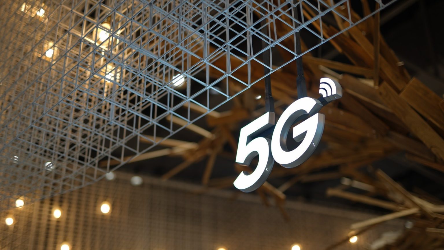 Symbole mit 5 G Zeichen hängt an einem Gitter.