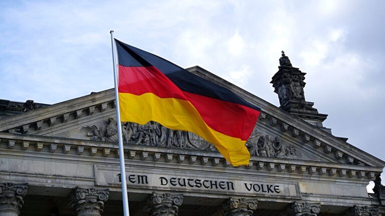 Die deutsche Fahne vor dem Schriftzug "Dem Deutschen Volke" am Reichstagsgebäude